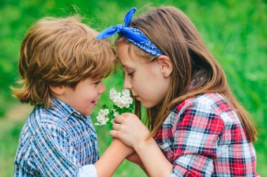 Sıcak yaz gününde gülümseyen ve gülen çocuklar dışarıda iyi vakit geçiriyorlar. Sevgililer Günü kartları. Çocuklar Sevgi Konsepti.