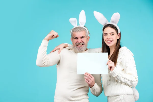Påsk par klädd i kostym med tom vit bräda för din text. påsk kanin par på blå bakgrund isolerad. — Stockfoto