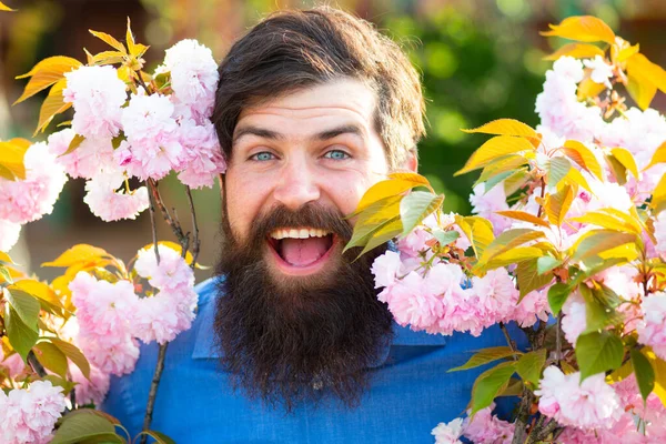 Partrait extérieur de jeune homme entouré de fleurs. Floraison printanière . — Photo