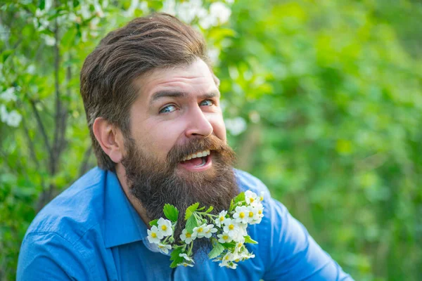 Gros plan portrait d'homme drôle modèle avec moustaches et barbe avec des flovers en chemise. Barbe fleurie . — Photo