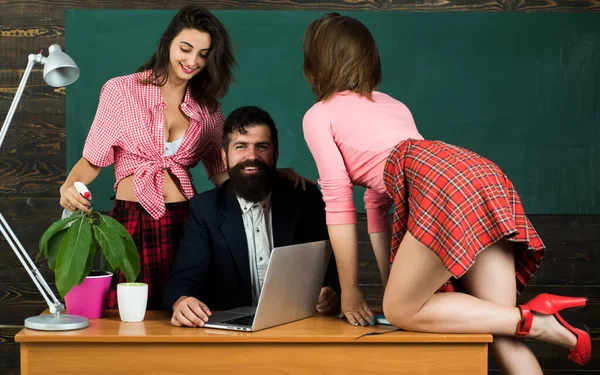 Sexology teacher looks at two sexy female students. Erotic education and sex. Symbols on chalkboard. Lets talk about sex. Handsome young bearded coach with two sexy students. — Stock Photo, Image