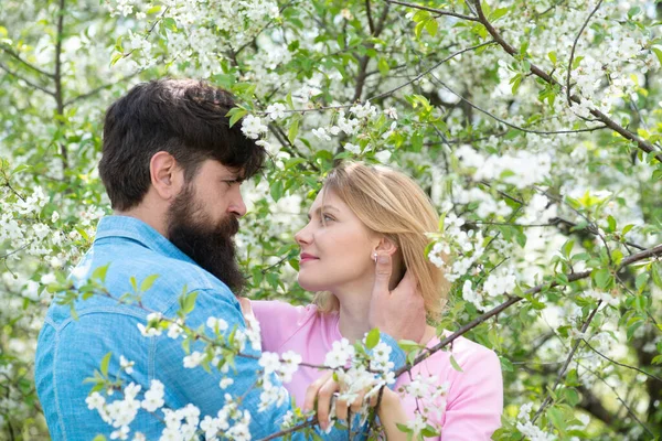 Женщина и мужчина наслаждаются идеальными отношениями и проводят спринф-каникулы. Молодая счастливая пара возле цветущего дерева . — стоковое фото