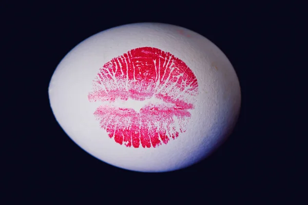 Kırmızı dudaklı beyaz yumurta üzerinde baskı. Easter egg siyah arka plan üzerinde kırmızı dudak Künye. — Stok fotoğraf
