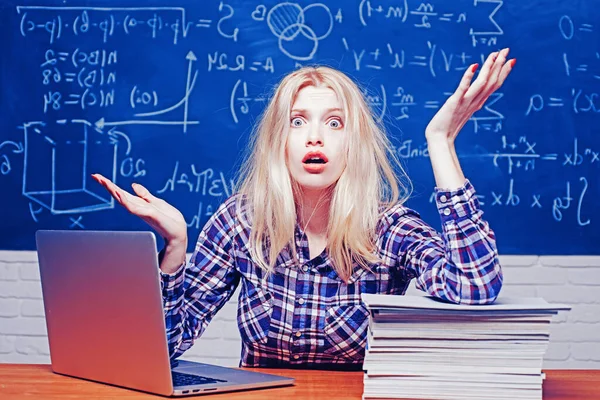 Emotionele boze studente schreeuwend op schoolbord achtergrond. Jonge student op hard examen voorbereiding in de studiezaal ziet er moe en moe. — Stockfoto