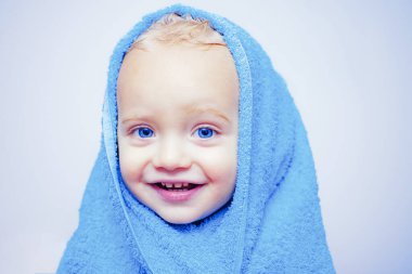 Gülümseyen güzel bebek duş altında evde banyo. Küçük bebek banyo şapkalı kabarcıkları ile yıkama. Mutlu Banyo zamanı. Bebek mavisi gözleri.