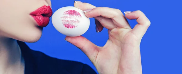 Feliz pancarta de Pascua. Huella de labio rojo en huevo de Pascua sobre fondo azul. Lápiz labial beso huella. Boca femenina . — Foto de Stock