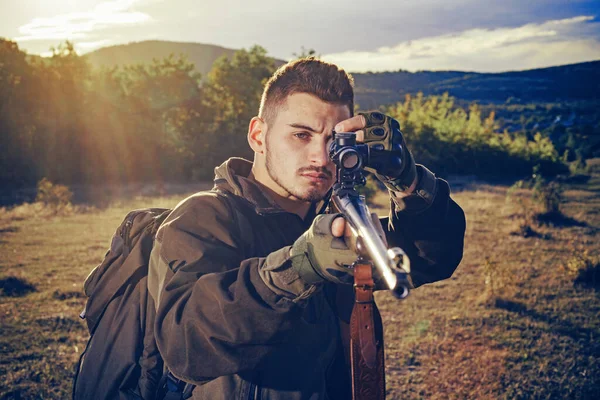 Jäger mit leistungsstarkem Gewehr mit Zielfernrohr, das Tiere beobachtet. Jäger-Klassiker. Jäger mit Gewehr auf Jagd. Jägermann. — Stockfoto