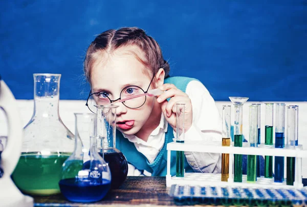 Vrolijk lachende pupil tekening aan het bureau. Portrair sluit af. Kind leert in de klas op de achtergrond van schoolbord. Het was een klein chemisch experiment. Scheikundeles. — Stockfoto