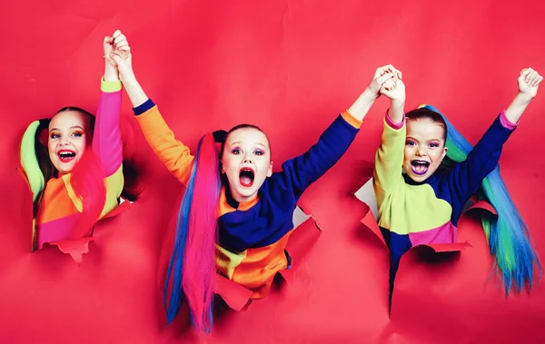 Zurück zur Party. Niedliche fleißige Kinder durchbrechen eine bunte Papierwand. Kinder, die sich an den Händen halten. Mädchen bereit zum Feiern. — Stockfoto