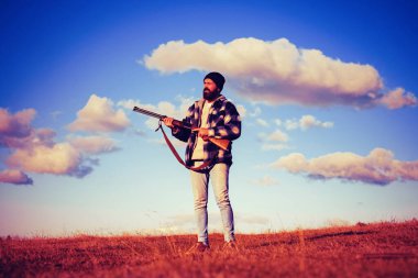 Silah tutan ve ormanda yürüyüş sakallı avcı adam. Hunter avı av tüfeği silah ile.