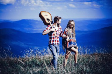 Dağlarda tatlı bir uyum. Mutlu gezginler yürüyüş yapar, gülümser ve gitar çalar..