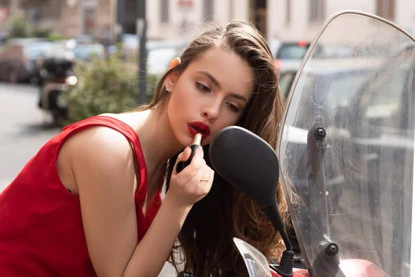 Outdoor lifestyle portrait of amazing glamorous luxury woman paint lips in city center. Young cheerful fashionable woman paint lips. Female fashion beauty and advertisement concept. — Stock Photo, Image