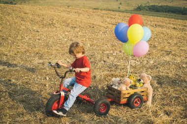 Retro motorsikletli küçük motorcular. Çocuk, şehir yolunda bisiklete biniyor. Güvenlik ve çocuk gelişimi kavramı. Rüya ve seyahat kavramı.