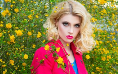 Sarışın, yüksek moda mankeni bir kız. Canlı Makyaj. Çiçek tarlası olan güzel bir model kadın. Bahar çiçekleri açan güzel kadın..