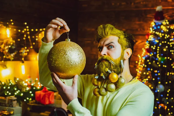 Hipster santa claus Kerst voorbereiding. Een close-upportret van een man met een baard in kerstmankostuum. Baard man met kerstballen. — Stockfoto