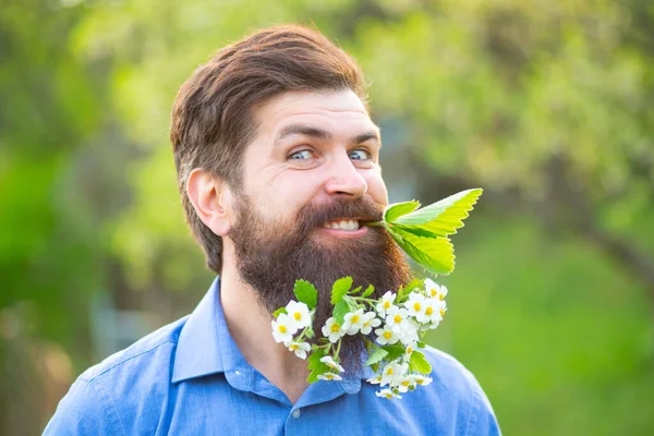 留着胡子的男人,留着春天的花朵,留着胡子.花胡子。一个留着胡子的男人在春花背景下看着相机的头像. — 图库照片