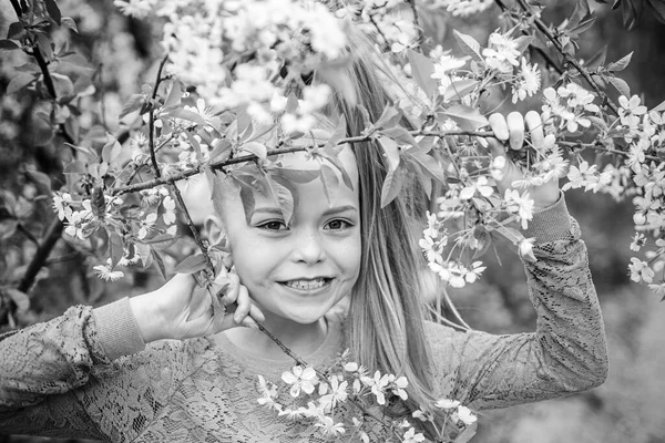 Smiling young girl standing outdoors behind the branches of a tree. Spring concept. Walk in a park. Activity Holidays. — 스톡 사진