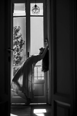 O mutlu dans eder. Balkonun yanında duran genç bir kadın. Yalnız bir kadın. Kendine güveni tam seksi bir kız. Tutku ve cazibe. Kız gece elbisesi giymiş..