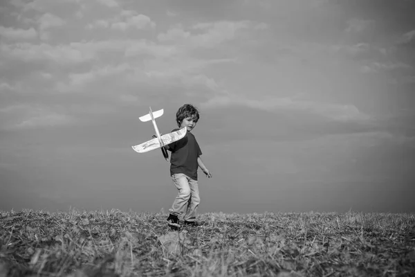 Childhood on countryside. Pilot aviator child with a toy airplane plays on summer nature. Boy with plane on meadow. Summer leisure. Child care. Cute toddler boy playing outdoors. — 스톡 사진