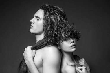 Birbirine aşık genç bir çift. Güzel genç bir çift. Sevgililer Günü 'nde oynaşan çiftlerin stüdyo fotoğrafları. Romantik ve aşk dolu. Baskın adam. Koyu arkaplanda.