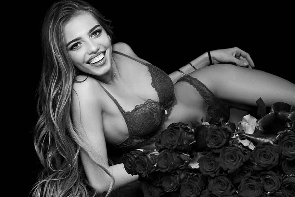 Κορίτσι και τριαντάφυλλο. Σέξι όμορφη γυναίκα κρατώντας μεγάλο μπουκέτο κόκκινα τριαντάφυλλα σε μαύρο φόντο. Όμορφη γυναίκα με κόκκινα τριαντάφυλλα. Ημέρα του Αγίου Βαλεντίνου. Valentine. — Φωτογραφία Αρχείου