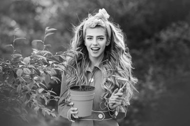 Aletleri olan bahçıvan kadın. Ekme ve çiçek yetiştirme konsepti. Bahar bahçesinde güzel bir kız. Çiçek saksısı tutan güzel kız.