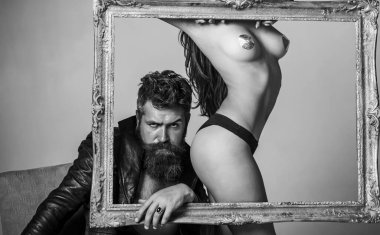 Seksi iç çamaşırlı kadın. Ellerinde klasik ahşap çerçeve var. Fotoğrafı kapat. Kaslı baskın adam. Samimi ilişki ve cinsel ilişki. Genç ve seksi bir çift. Erotik oyunlar arzu.