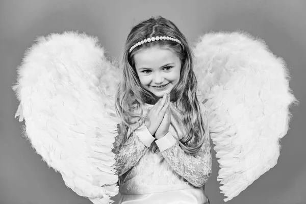 美しい天使の娘お前の拳で立っている謎の天使の少女あなたの胸の近くにあなたの腕で立っている美しい小さな天使の女の子祈りのように. — ストック写真