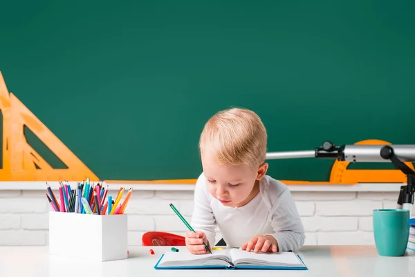 文字や数字を学びます。教室で教師の勉強をするかわいい就学前の子供の男の子。初日だ. — ストック写真