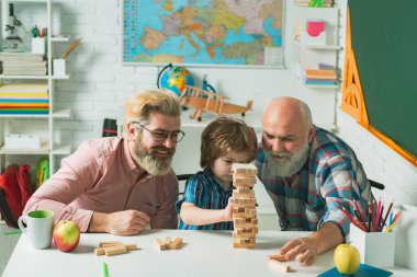 Babam ve dedemle birlikte evde eğlenen bir öğrenci. Mutlu erkek ailesi birlikte eğleniyor. Farklı yaşlarda bir adam. Aile için Jenga oyunları.