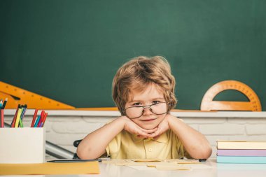 Öğrenci harf ve sayı öğreniyor. Çocuklar okula hazırlanıyor. Evde eğitim. Sınıfta, tahtaya yakın arkadaş canlısı bir çocuk. Yetenekli çocuk. Çocuk sınıfta tahtada öğreniyor..