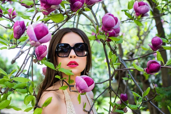 Ritratto di bella ragazza con pelle pulita su bel viso su sfondo di fiore Magnolia . — Foto Stock
