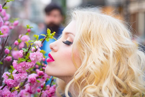 Bahar çiçekleri açan güzel bir kadın. Bir demet çiçeğin yanında güzel bir kız ve açık havada gülümsüyor.. — Stok fotoğraf