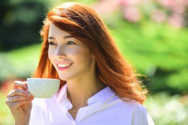 Bahar gülümsemesi. Çiçek parkında mutlu, güzel, gülümseyen bir kadın kahvesi..