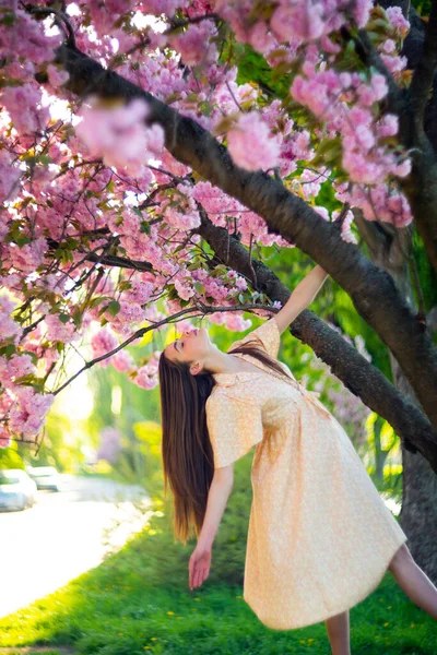 Feliz hermosa mujer joven en el parque de flores de primavera . — Foto de Stock
