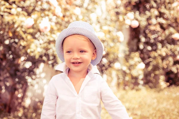 Счастлив. Беззаботное дитя. У ребенка летняя радость. Счастливый мальчик, стоящий в траве в солнечный летний день . — стоковое фото
