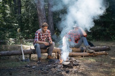 Yaz tatili ormanı. Yaz tatili. Bir grup genç dışarıda eğleniyor. Ormanda oturup bira içen iki oduncu arkadaş. Arkadaşlar kamp ateşinde eğleniyor..