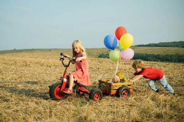 Amizade e apoio. Irmão e irmã agricultores de bicicleta se divertindo no campo de primavera. Crianças agricultor na fazenda com fundo rural. Vida agrícola americana . — Fotografia de Stock