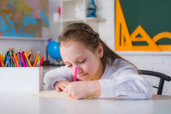 Індивідуальне навчання. Симпатична маленька дівчинка малює вдома Симпатичний хлопчик з учителем в класі біля дошки столу . — стокове фото