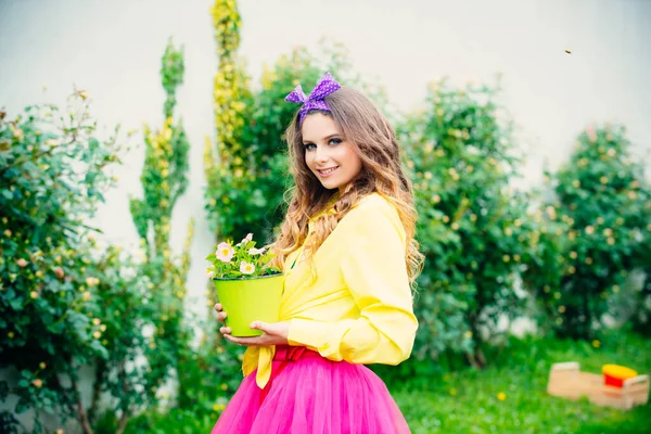 Teenager girl gardening. Young beautiful woman with flower pots over green nature background. Spring concept. — Stock fotografie