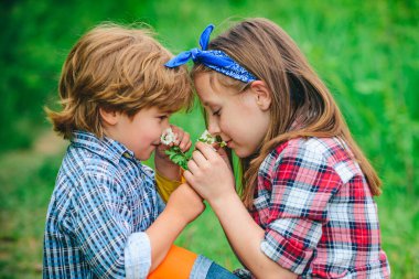 Sevgililer Günün kutlu olsun. Güzel çocuklar bahar parkında karahindiba üflemekten hoşlanır..