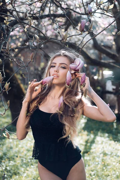 Outdoor-Porträt einer jungen schönen modischen Frau mit Blumen. Frühlings-Stil. Schöne junge brünette Frau im schönen Frühlingskleid. Mode Frühling Sommer Foto. — Stockfoto