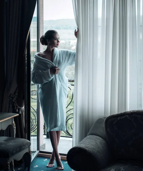 Жінка вранці. Приваблива сексуальна жінка стоїть біля вікна в її будинку і має ідеальний затишний ранок . — стокове фото