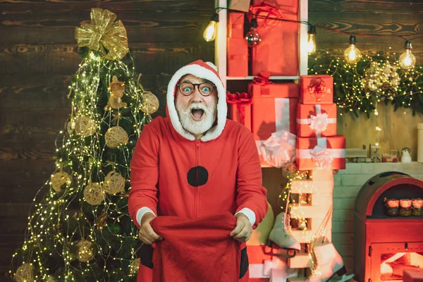 Un hombre guapo vestido de Navidad. Concepto de año nuevo. Barbudo hombre divertirse cerca de árbol de Navidad en el interior . —  Fotos de Stock