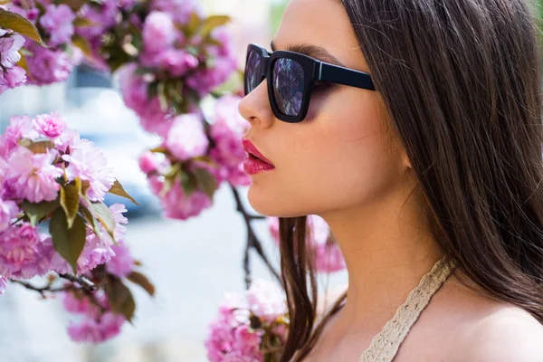 Close up ritratto di bella ragazza con la pelle pulita sul bel viso su sfondo fiore primaverile . — Foto Stock