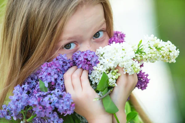 Menina adolescente com buquê de lilás roxo e branco. Olhos e flores . — Fotografia de Stock