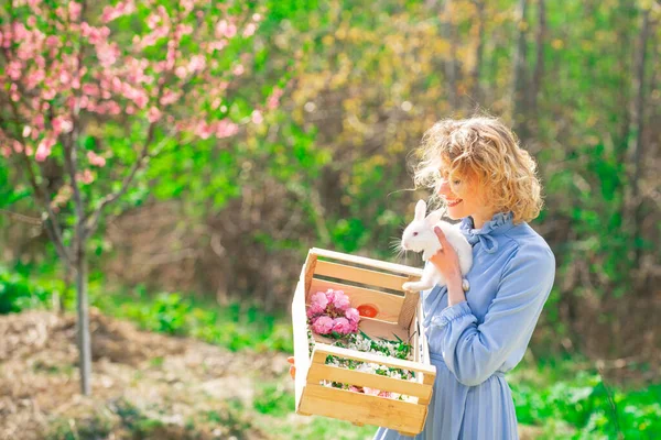 Hermosa joven con conejo en la granja. Retrato de mujer joven posando con conejo. — Foto de Stock