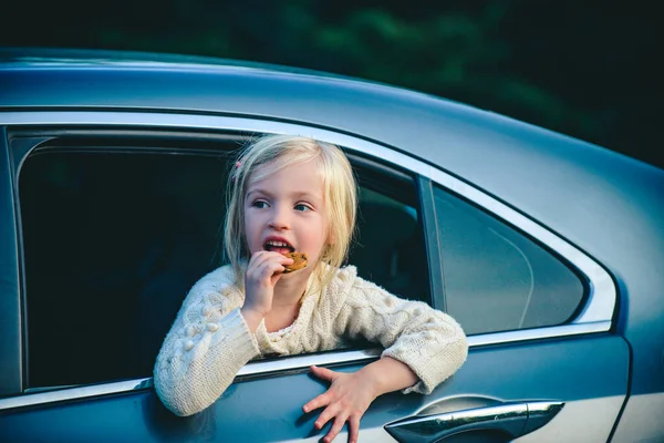 Menina sonhando olhar para fora da janela do carro. Retrato de menina criança sentada no carro. Bonito menina criança sorrindo e se divertindo para viajar de carro . — Fotografia de Stock