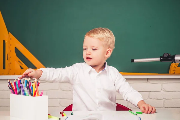 Kinderen van de lagere school. Gelukkige schoolkinderen bij de les. Vriendelijk kind in klaslokaal bij schoolbord. — Stockfoto
