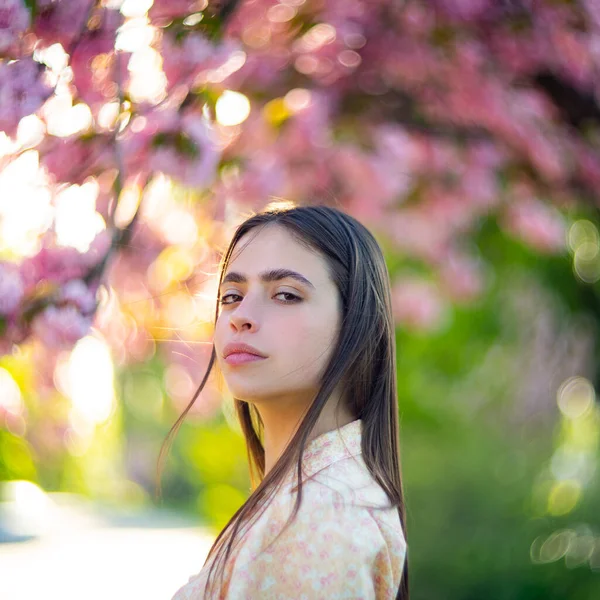 Foto de moda ao ar livre de bela jovem rodeada de flores. Flor de primavera Flor de cereja . — Fotografia de Stock
